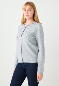 Grijze wollen cardigan met versieringen aan de voorkant, een ronde halslijn en geribbelde manchetten. Klassieke pasvorm met knoopsluiting.