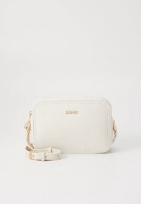 Sac bandoulière en cuir couleur crème avec ferrures dorées, forme rectangulaire, détails de couture et sangle réglable. Présente un logo à l'avant.