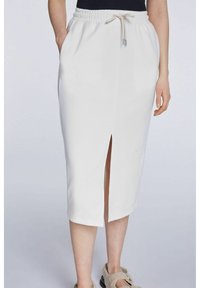 Jupe midi blanche avec une taille à cordon et une fente latérale. Faite d'un tissu doux, elle comporte deux poches latérales et une texture lisse.