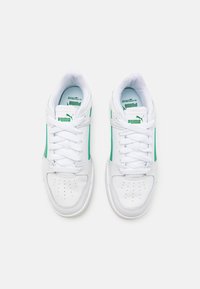 Hvite sneakers med grønne accenter, syntetisk læremateriale, rund tå, perforerte detaljer på tåboksen, og snøredesign.