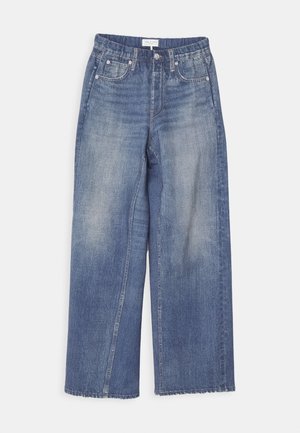 Széles lábú, koptatott kék farmernadrág, gombos záródással, övhurkokkal és két elülső zsebbel. A rojtos szegély textúrázást ad.