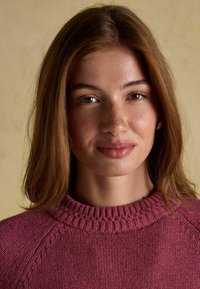 Burgundi värvi kudumiga kampsun ribitatud ümarate kaelustega. Pehme tekstuur, õlgadel on peened detailid. Loomulik nahatoon ja tedretäpid.