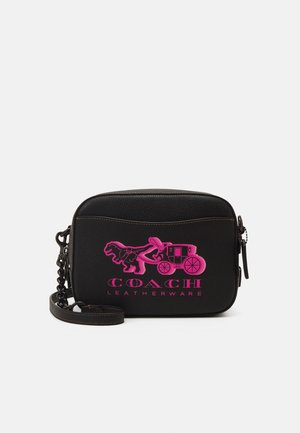 Czarna skórzana torba na ramię z różowym logo Coach przedstawiającym dinozaura ciągnącego powóz oraz napisem „LEATHERWARE”, na jednolitym tle.