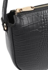 Zwarte leren handtas met krokodillenstructuur, gouden rits met gegraveerde tekst "Paul Costelloe London," en een zichtbare korte schouderriem.