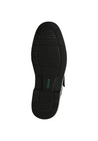Suola di scarpa in gomma nera con motivi testurizzati, inclusi linee orizzontali e verticali. Presenta un'etichetta verde vicino al tallone.