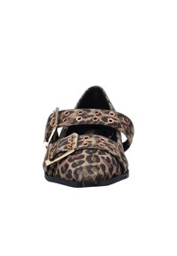 Leopardprint platte schoen met dubbele banden, gouden hardware en puntige neus. Zachte textuur met een zwarte zool en grommetaccenten.