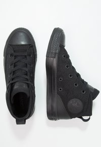 Czarne sneakersy za kostkę z teksturowanym płóciennym cholewą, gumowym noskiem i podeszwą. Posiadają czarne sznurówki, przelotki oraz teksturowany tył pięty.