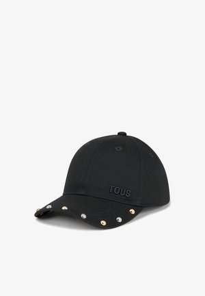 Gorra de béisbol negra con "TOUS" bordado en el centro delantero y tachuelas metálicas plateadas y doradas a lo largo de la visera curva.