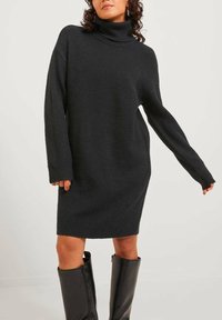 Abito a collo alto in carbone realizzato in un tessuto a maglia testurizzata, dotato di maniche lunghe, una vestibilità ampia e lunghezza fino a metà coscia.