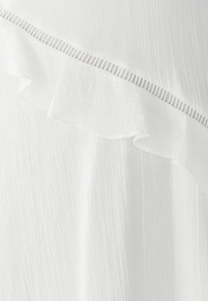 Tissu blanc avec un motif texturé et froissé. Présente un bord festonné et un accent rayé fin le long de la couture. Matériau doux et léger.