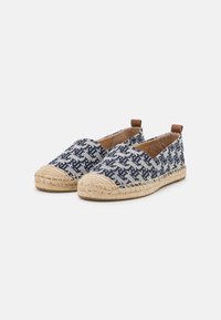 Marinblå espadrillos med mönster, vävd tyg, naturlig jutesula och bruna läderdetaljer vid hälen och sidorna. Platt slip-on design.