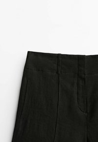 Pantalons en lin noir avec une taille plate, des poches latérales et une texture lisse, conçus avec une coupe ajustée pour une silhouette épurée.