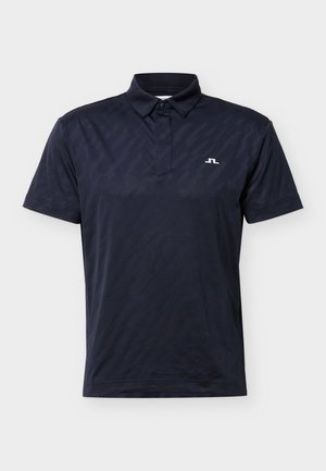 Tamsiai mėlynas polo marškinėliai trumpomis rankovėmis su sagomis apykaklėje ir maža balta logotipu ant kairės krūtinės.