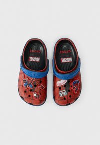 Crocs Spider-Man aux couleurs rouge et bleu, avec des marques Marvel et des charms décoratifs sur fond blanc.
