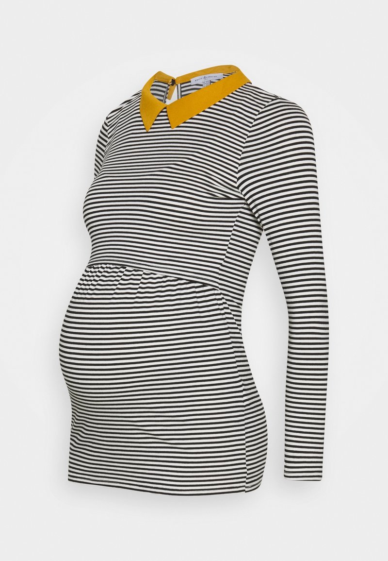 Svart och vit randig graviditetstopp med rund krage i senap. Har långa ärmar och ett elastiskt midjeband för en bekväm passform.