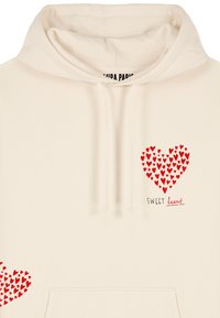 Beige hoodie med ett stort rött hjärt-mönster och texten "SWEET heart" i svart, med dragsnodd i huvan och en framficka.