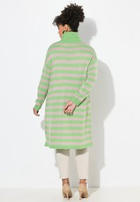 Abito a maglione a righe in verde chiaro e beige, con un alto colletto e maniche lunghe. Tessuto lavorato morbido, con un design lungo fino al ginocchio.