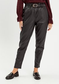 Mustat keinonahka-housut, joissa on korkea vyötärö, vyölenkit ja vyö, jossa on kultainen pyöreä solki. Slim-fit-malli, jossa on taskut.