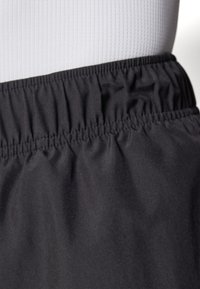 Schwarze Sportshorts mit elastischem Bund und glattem Material, versehen mit Faltendetails entlang der Taille und leichtem Stoff.