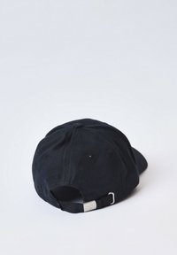 Gorra de béisbol de algodón negro con visera curva, correa ajustable en la parte trasera y detalles de costura. Lleva una pequeña etiqueta con un logo en el lateral.