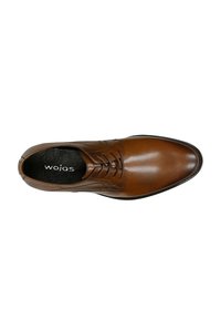 Scarpa elegante in pelle marrone con design slanciato, punta tonda, dettagli cuciti e suola piatta. L'interno è rifinito con una fodera nera con il marchio.