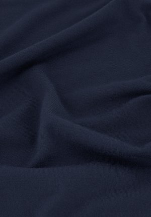 Marineblauwe zachte stof met fijne gebreide textuur en zachte plooien die subtiele schaduwen en highlights creëren.