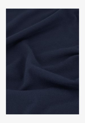 Marineblauwe zachte stof met fijne gebreide textuur en zachte plooien die subtiele schaduwen en highlights creëren.