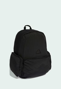 Schwarzer Nylon-Rucksack mit abgerundeter Form, ausgestattet mit einer Fronttasche mit Reißverschluss, Logodetail und einem gepolsterten oberen Tragegriff.