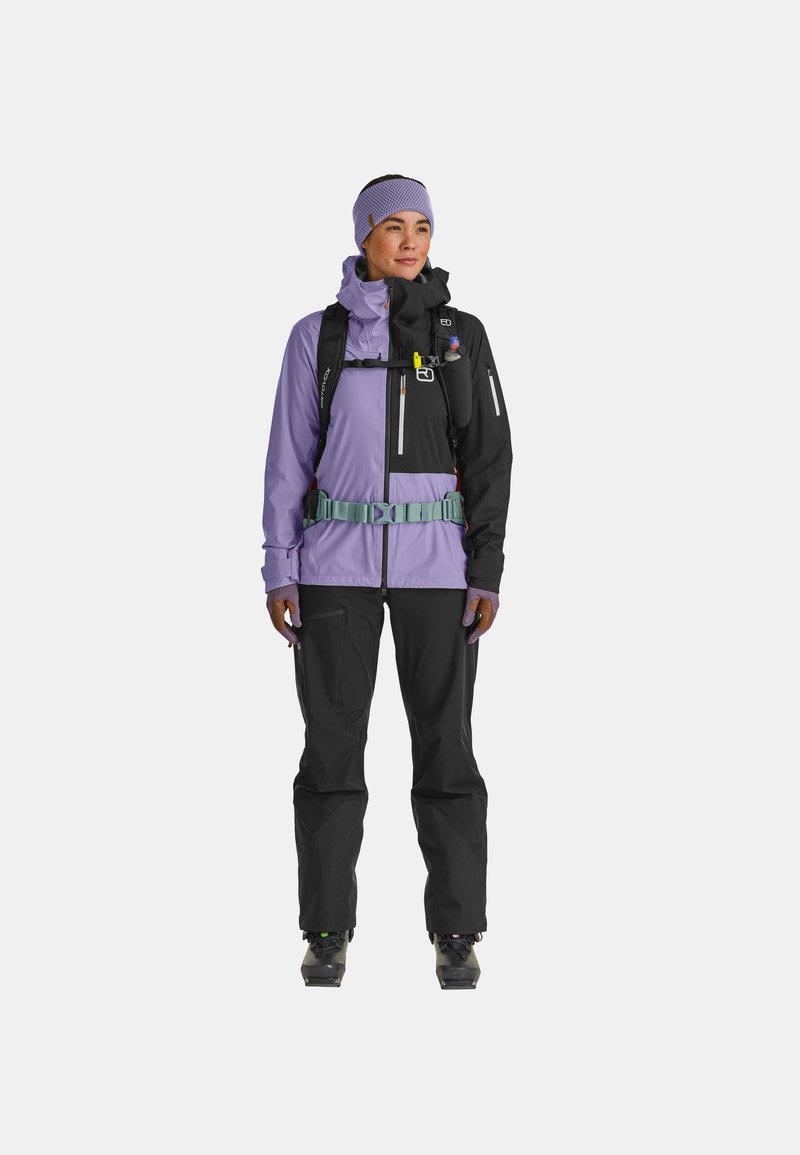 Ski outfit featuring a purple and black waterproof jacket, adjustable mint green belt, and black pants. Includes pockets and a headband.