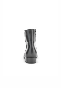 Bota de tobillo de cuero negro con textura suave, punta redondeada y tacón pequeño. Cierre de cremallera trasera visible a lo largo de la costura central.