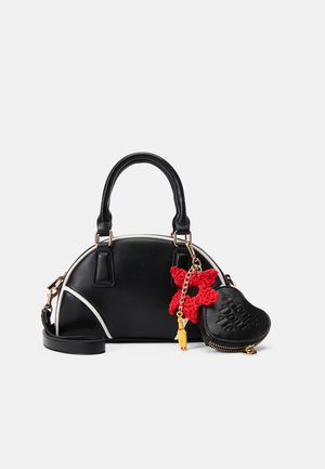 Borsa nera a forma arrotondata, con accenti bianchi e due manici. Presenta un charm a forma di fiore rosso all'uncinetto e una pochette con zip a forma di cuore.