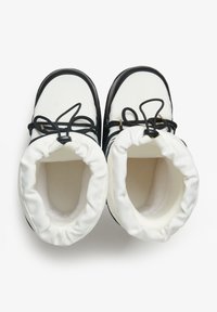 Bottes isolées blanches avec accents noirs. Bout rond, cordon de serrage en haut, intérieur matelassé, matériau extérieur texturé. Design ouvert pour un accès facile.