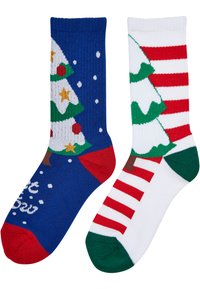 Stricksocken mit einem blauen Design, das auf der linken Seite Weihnachtsbäume und Schneemotive zeigt; rechts ein weiß gestreiftes Muster mit Baum und grünen Akzenten.