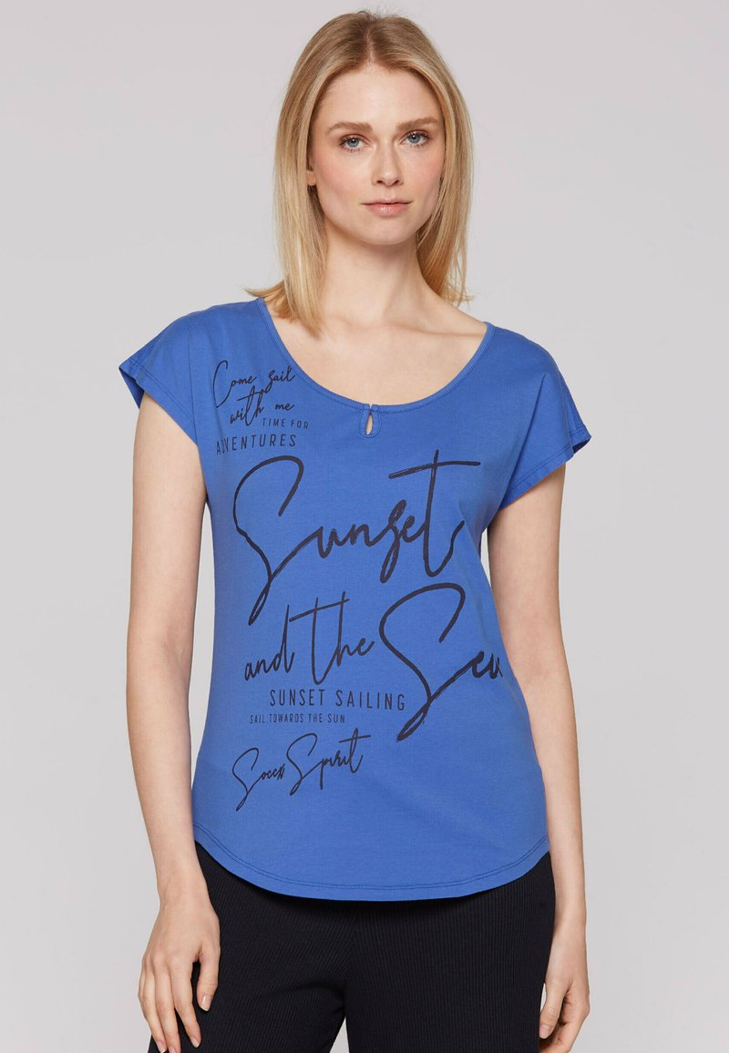 Blauwe T-shirt met korte mouwen en een ronde halslijn, met zwarte bedrukte tekst en een klein sleutelgatdetail aan de voorkant.