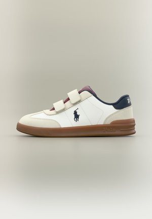Hvid og beige sneaker med brun sål, to velcrostropper, navyblåt Polo-logo og navy hælkappe med Polo-mærke.