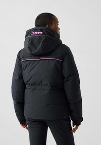 Giacca a vento nera con cappuccio, con un accento rosa sulle spalle e marchio sul retro. Texture liscia, chiusura con zip.