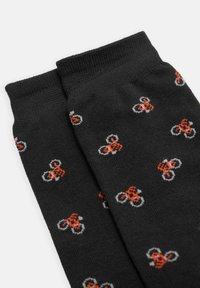 Calcetines negros con un acabado texturizado, que presentan un patrón repetitivo de pequeñas bicicletas naranjas y grises.