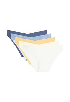 Vrouw draagt naadloos, hoog uitgesneden blauw ondergoed, getoond van taille tot bovenbenen tegen een lichte achtergrond.
