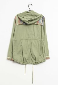 Kurtka w oliwkowym kolorze z kapturem i wzorzystym karczkiem w odcieniach czerwieni, niebieskiego i różowego. Posiada regulowany ściągacz w talii oraz elastyczne mankiety.