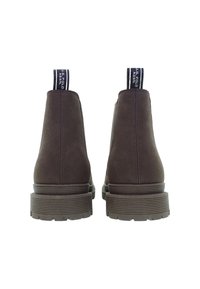 Stivali ankle in suede marrone scuro con suole in gomma spesse e linguette con marchio sul retro, mostrati di profilo su uno sfondo bianco.