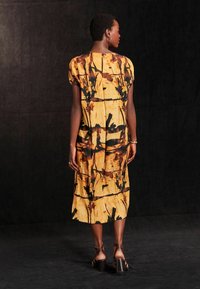 Next Päevakleit - ochre yellow and black print