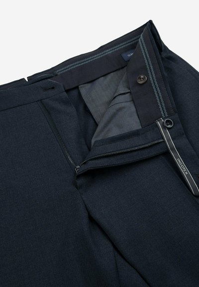 Pantalons bleu marine avec une texture lisse, dotés d'une fermeture éclair et d'un bouton. Les détails intérieurs comprennent une doublure à rayures discrètes et une étiquette de logo.