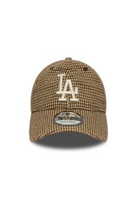 Bruine houndstooth pet met een gebogen rand, verstelbare band en geborduurd wit "LA" logo aan de voorkant. De stof heeft een gestructureerd patroon.