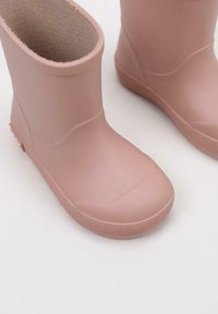 Stivali da pioggia in gomma rosa con un esterno liscio, punta arrotondata e parte superiore elasticizzata. Suola testurizzata per grip e tacco rinforzato.