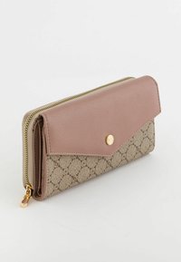 Cartera de textura beige y marrón con cremallera dorada y botón de presión, que presenta un patrón geométrico en la tela y una solapa de cuero suave.