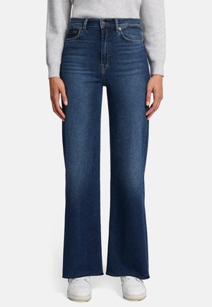 Jean en denim à jambes larges avec une taille mi-haute, couleur bleu foncé et détails de couture subtils. Doté d'un design classique à cinq poches et de quincaillerie en métal.