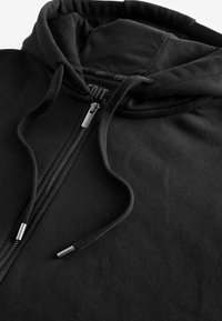 Black zip-up hoodie with adjustable drawstrings. Features a soft cotton blend, smooth texture, and silver zip hardware.