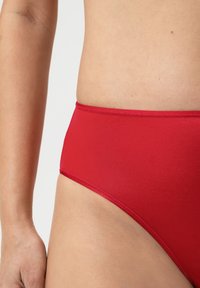 Rode bikini onderkant van gladde stof, met een middenhoog design, in een effen kleur met nette stiksels langs de tailleband en de beenopeningen.