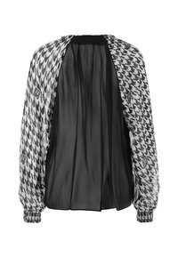 Schwarz-weiße Bluse im Hahnentritt-Muster mit transparentem schwarzen Rücken, elastischen Bündchen und gerafftem Halsausschnitt.