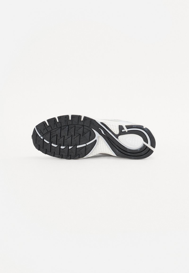 Schwarze und weiße Sportschuhsohle mit strukturiertem Gummi-Profil für Grip, mit einem geschwungenen Design und geformten Akzenten für Stabilität.